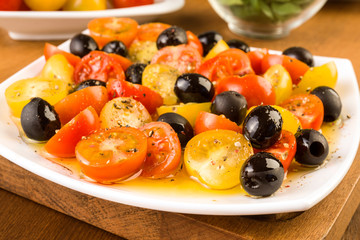 salad with cherry tomatoes and olives on wooden
