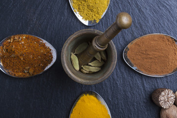 oriental indian spices curry paprika nutmeg on slate