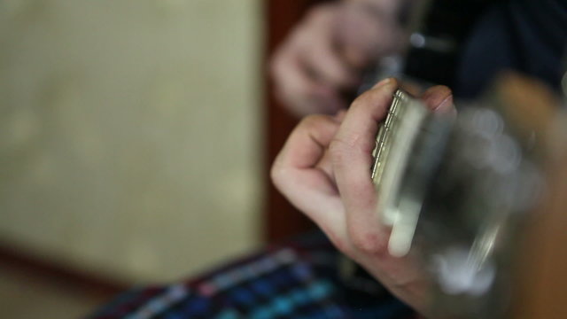 man plays guitar, his fingers on the fretboard closeup