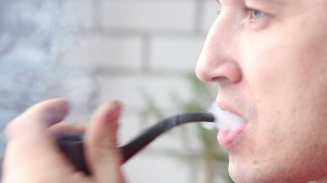 man smoking a pipe closeup