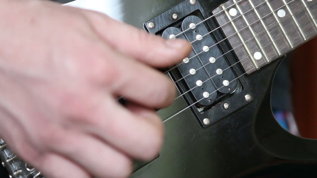 man playing the electric guitar brute force, close-up
