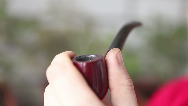 man smoking a pipe, close-up