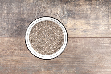 Chia seeds in a bowl on wooden background