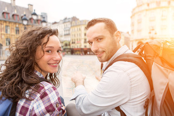 Couple of young attractive tourists watching map