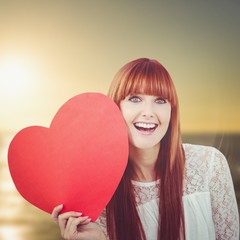 Composite image of smiling hipster woman with a big red heart