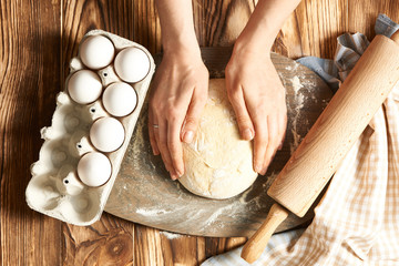 Female hands kneading dough