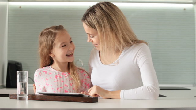Child with mother looking at tablet