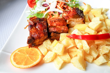 Grilled meat ribs on the plate with hot sauce