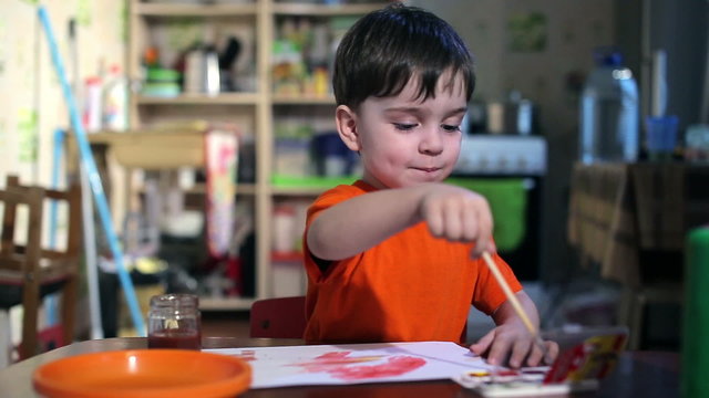 Joyful child at the table with a brush