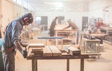Man doing woodwork in carpentry / Carpenter work on wood plank in workshop