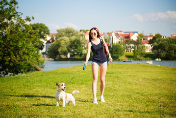 Naklejka na ściany i meble Young Woman with her Dog Walking in the Park