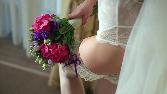 Bride Near Wedding Bouquet of Flowers. The Bride in Lingerie.