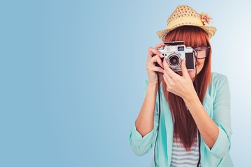 Composite image of portrait of a smiling hipster woman holding a camera