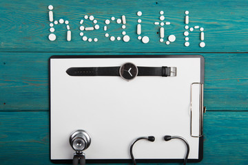 Health concept - pills, stethoscope, clipboard and  watch