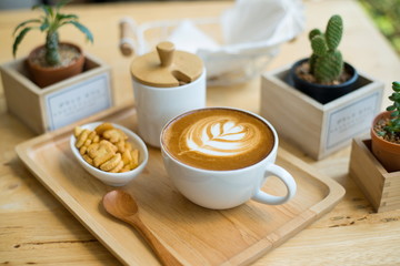 hot latte art  with cactus in coffee shop on table wooden
