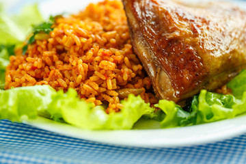 Delicious dish of chicken thigh with rice and salad leaves
