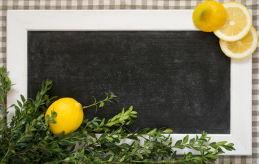 Lemons and branches of buxus on the background of black chalkboard