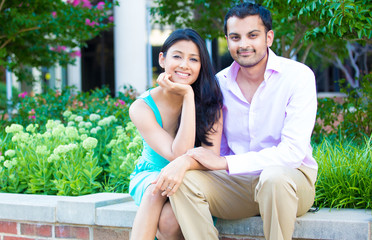 Naklejka premium Closeup portrait, attractive wealthy successful couple in pink shirt and green dress holding each other smiling, isolated outside stairwell background.