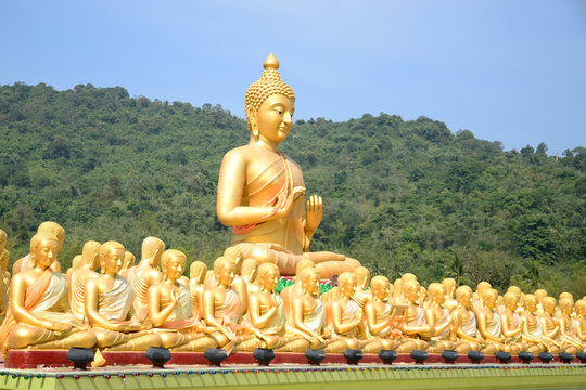 Big Golden and thousand of Golden Buddha statues with green moun