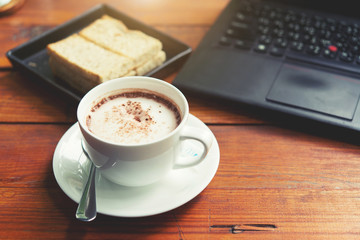 Hot chocolate is served with hot bread between the notebook.