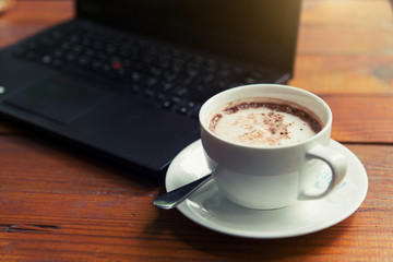 Hot chocolate is served with hot bread between the notebook.