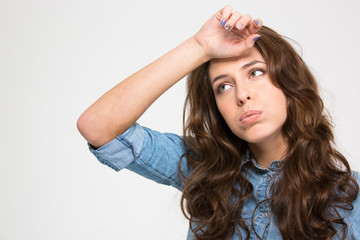 Fototapeta premium Sad tired young woman with hand on forehead