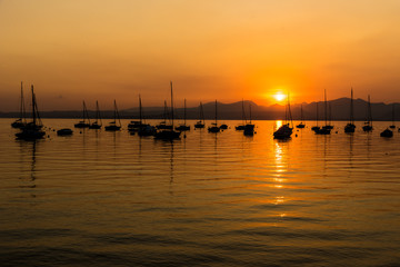 Sailing Boats on lake Garda with sunset, Italy