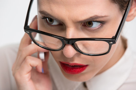 Serious conentrated business woman in glasses talking on cell phone