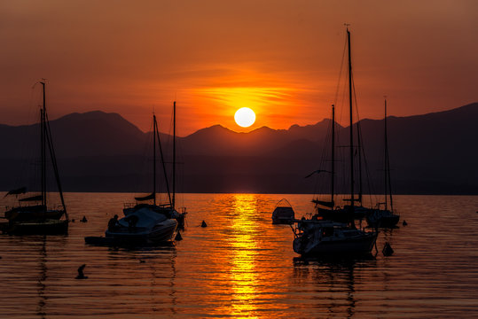 Sailing Boats on lake Garda with sunset, Italy