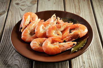 boiled shrimp on a plate on a wooden background