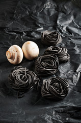 five servings of black pasta with cuttlefish ink and two mushroo