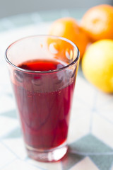 Glass of Red Grape and Orange Juice on the Table, Close-up, Vertical.