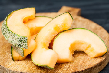 slices cantaloupe melon on cutting board. Kitchen table.