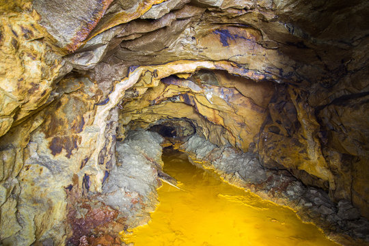 Old abandoned gold mine tunnel passage with yellow sulfur dirt