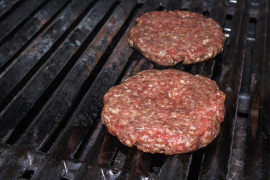 Raw Hamburger Patties On Grill