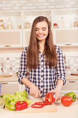 Obraz na płótnie Canvas beautiful girl preparing vegetarian salad in the kitchen