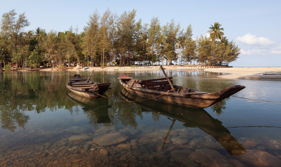 Two boats on the river beach with tropical forest near the sea