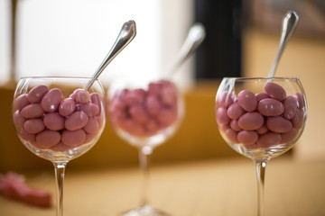 Pink sugared almonds in a glass. Wedding icon