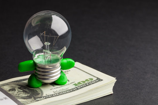 light bulb and dollar on black background