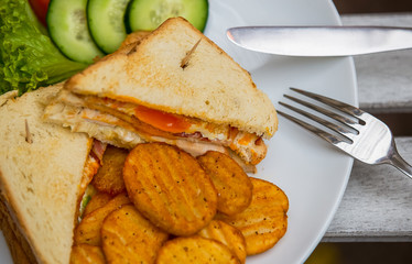 Sandwich with eggs and ham, served on a white plate. Breakfast, dinner.