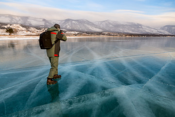 A photographer on the ice of lake Baikal