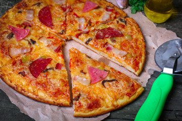 close-up Delicious Meat Pizza with Ham, Bacon and sausages on the wooden background