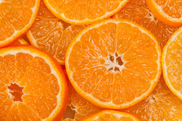 Fototapeta na wymiar bright orange background from slices of juicy mandarins