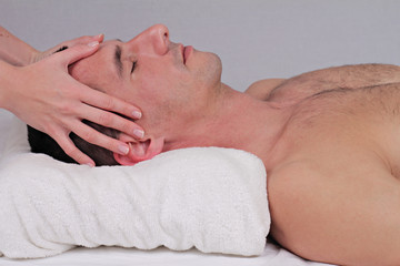 Fototapeta na wymiar Man Enjoying Face Head Massage. Relaxation, spa treatment, wellness concept