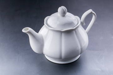 teapot and tea cup over dark background