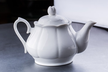teapot and tea cup over dark background