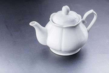 teapot and tea cup over dark background