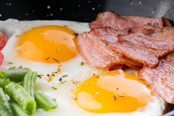 Fried egg on a pan served with tomato and asparagus