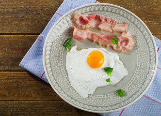 Fried egg with bacon for breakfast.