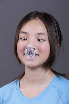 Girl looks at popped gum on her nose.